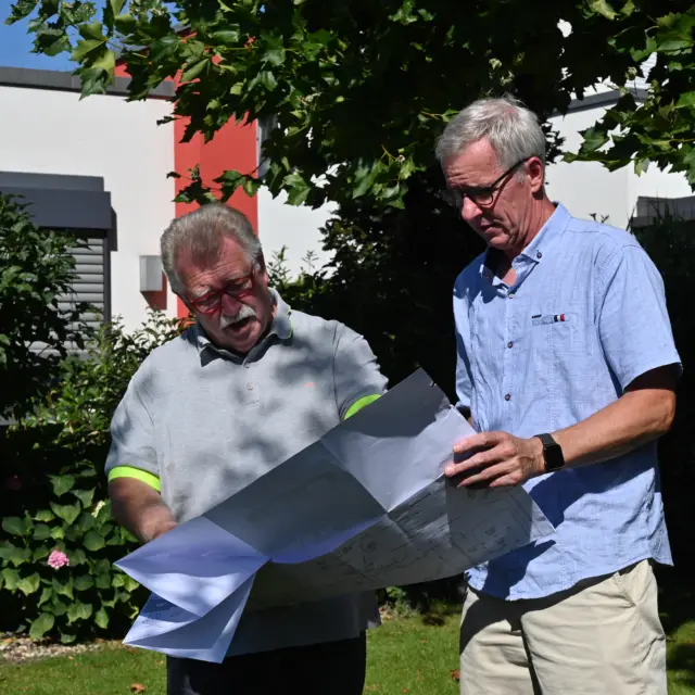 Moderner Rechteckpool mit Rasenfläche und Sonnensegel im Garten