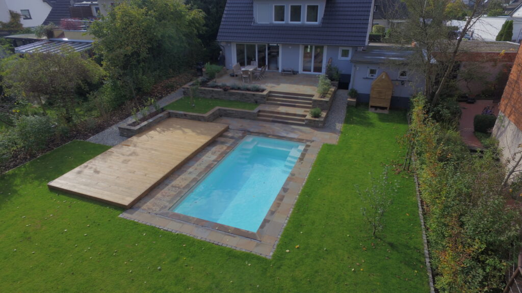 Pool mit verschiebbarem Holzdeck im Garten
