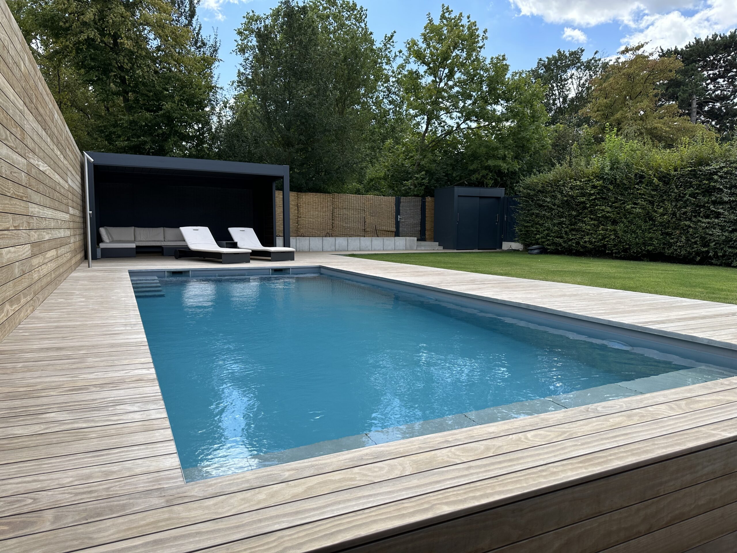 Moderner Pool mit Holzterrasse und Loungebereich