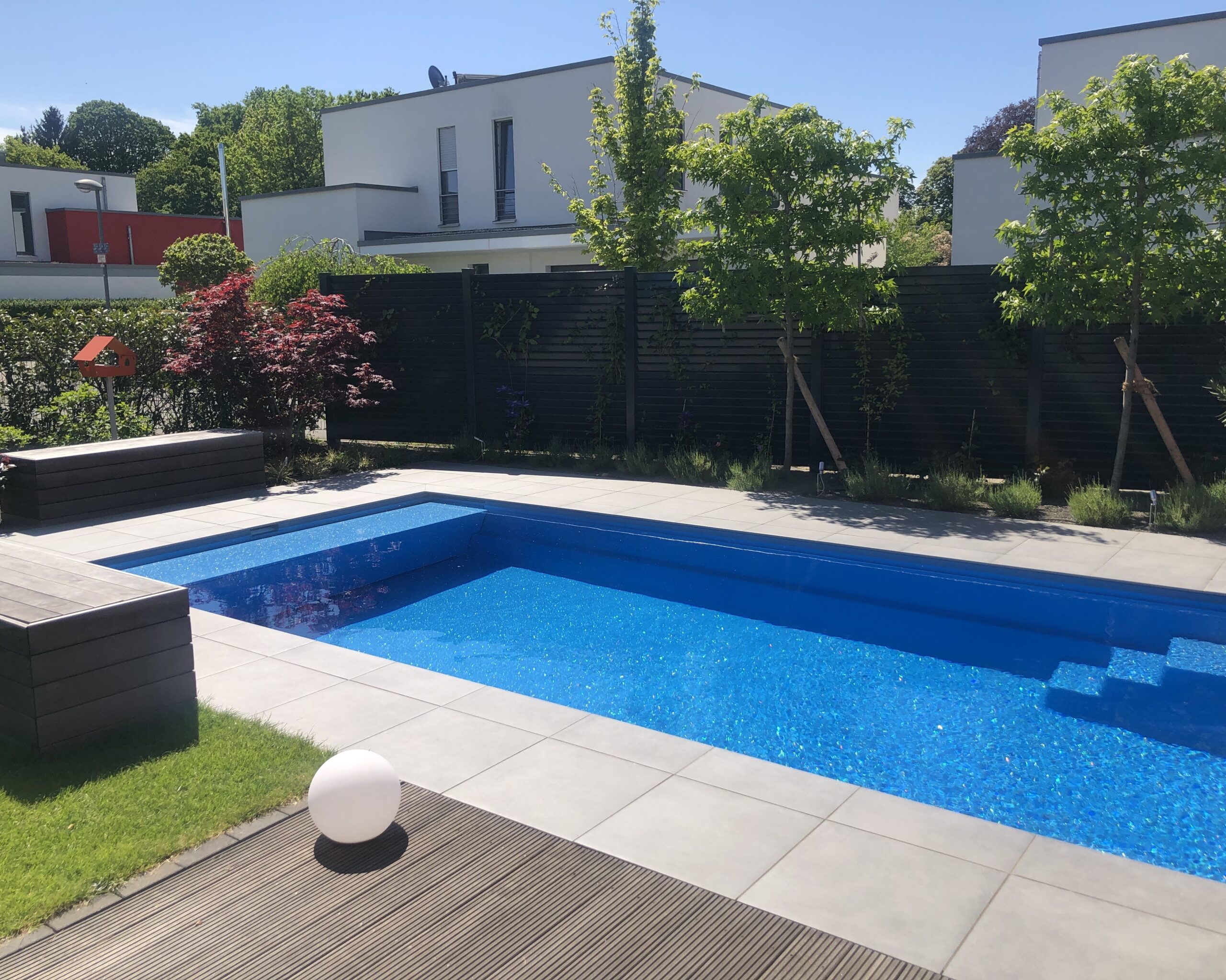 Swimmingpool mit Sitzbänken und Sichtschutz