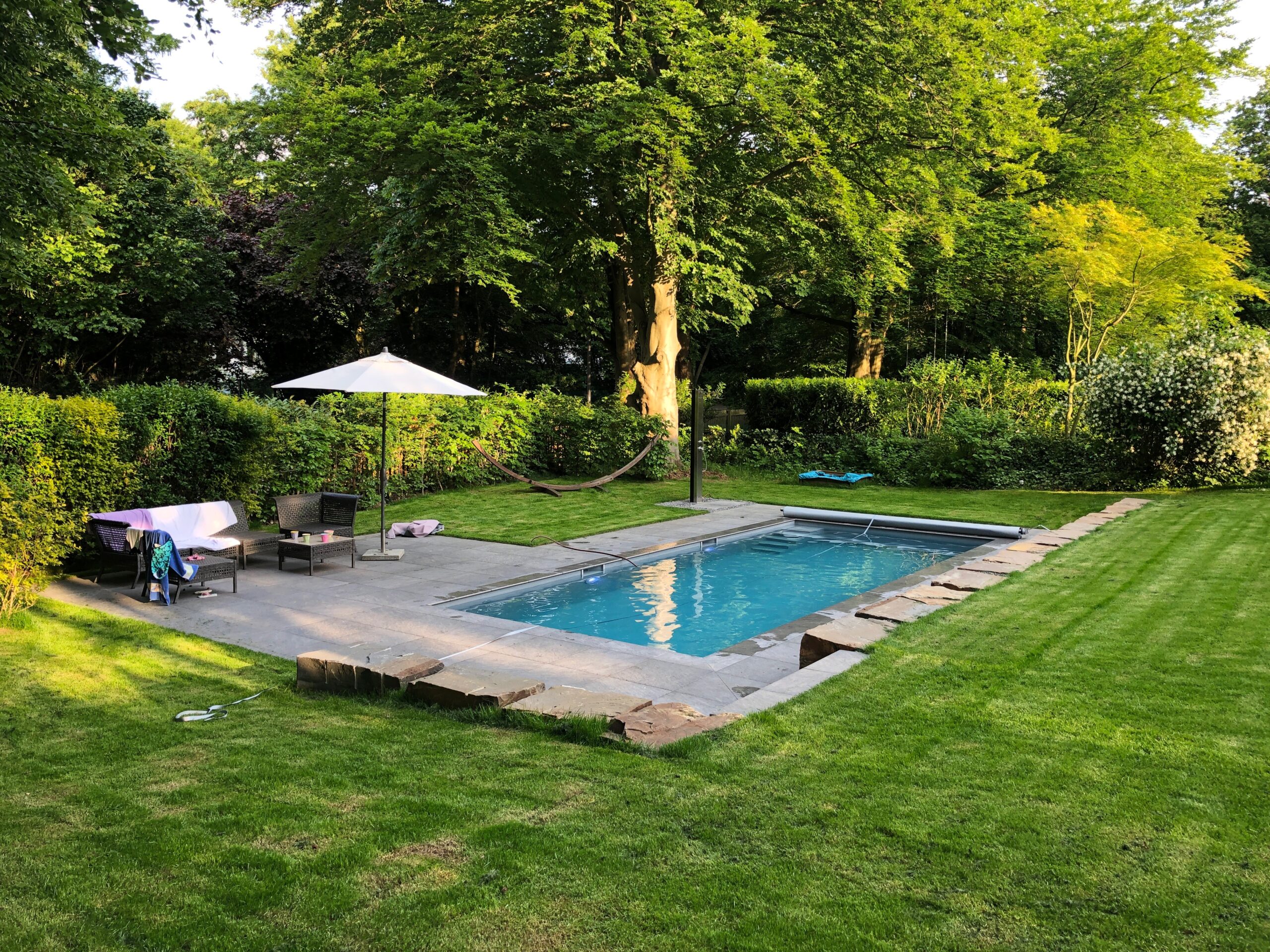 Pool mit Natursteinmauer und Terrassenbereich