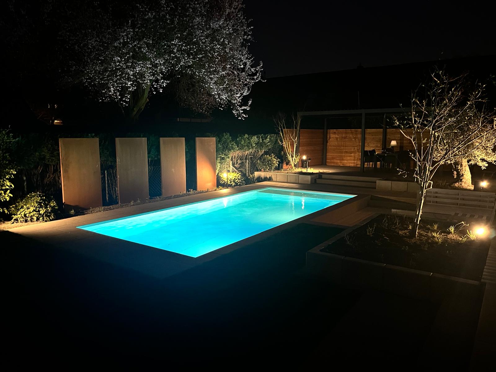 Beleuchtete Poolanlage als Beispiel für hochwertigen Poolbau