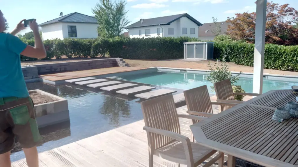 Hybridpool mit Natursteinelementen und Holzterrasse