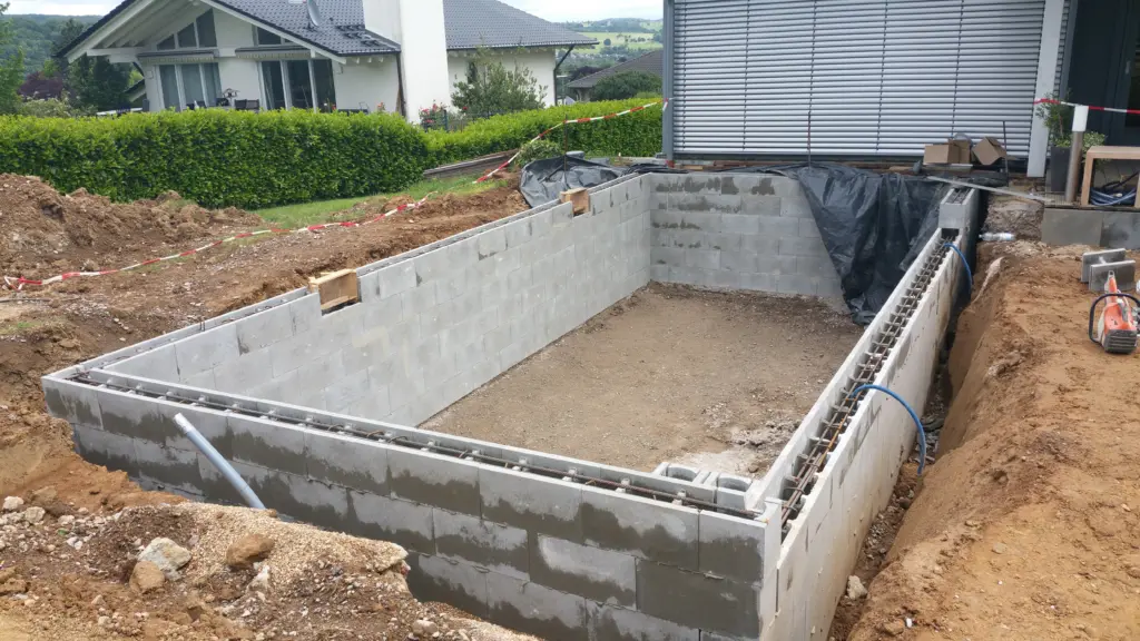 Hybridpool mit Natursteinelementen und Holzterrasse