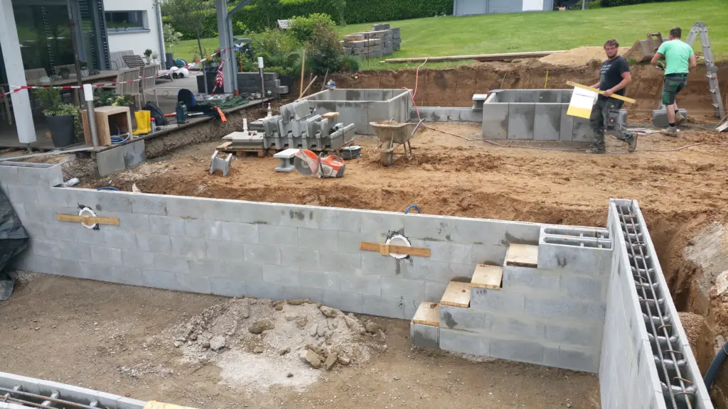 Hybridpool mit Natursteinelementen und Holzterrasse