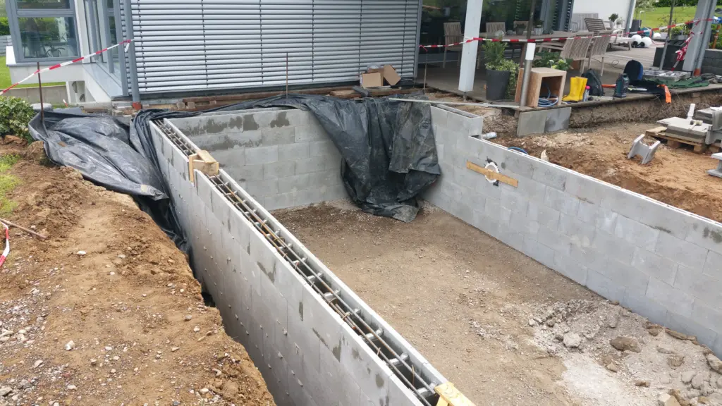 Hybridpool mit Natursteinelementen und Holzterrasse