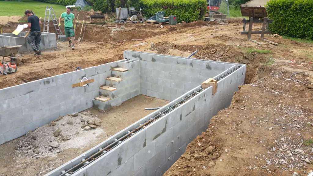 Hybridpool mit Natursteinelementen und Holzterrasse