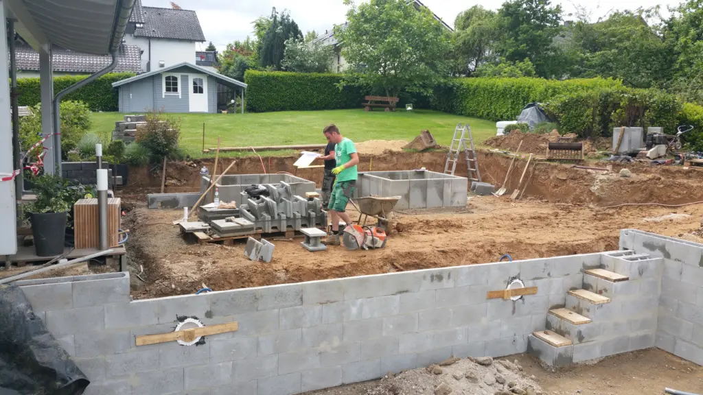 Hybridpool mit Natursteinelementen und Holzterrasse