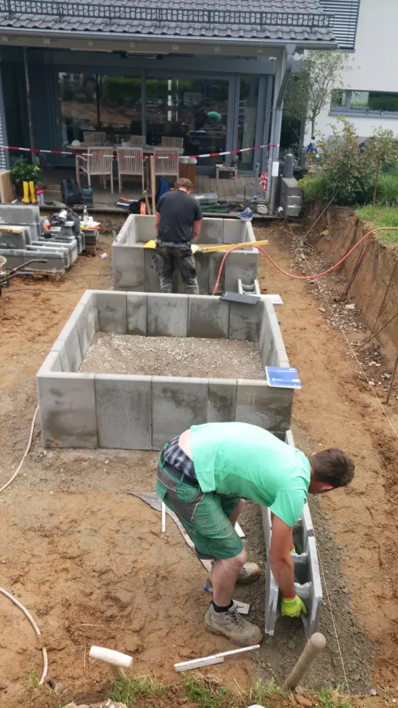 Hybridpool mit Natursteinelementen und Holzterrasse