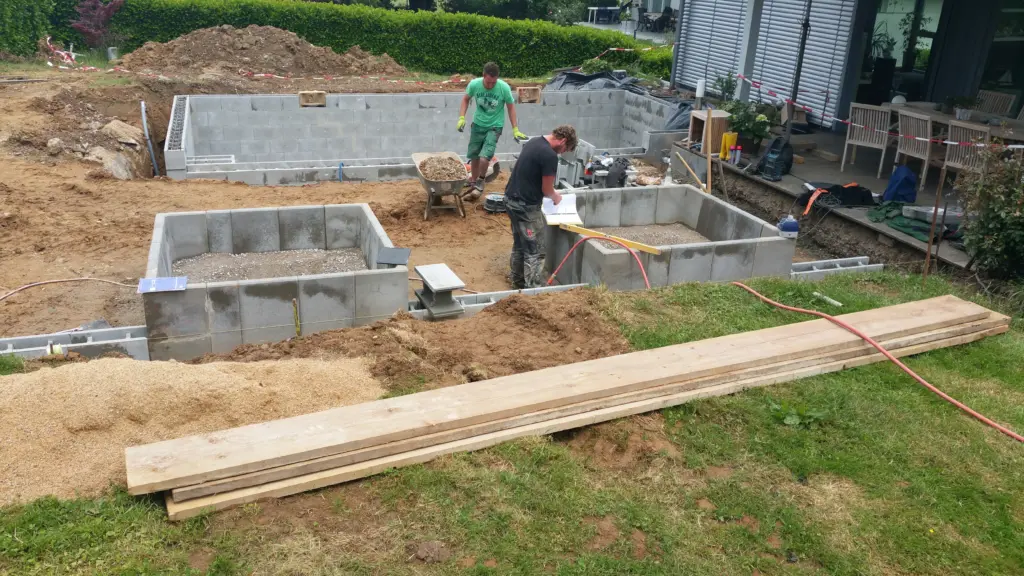 Hybridpool mit Natursteinelementen und Holzterrasse