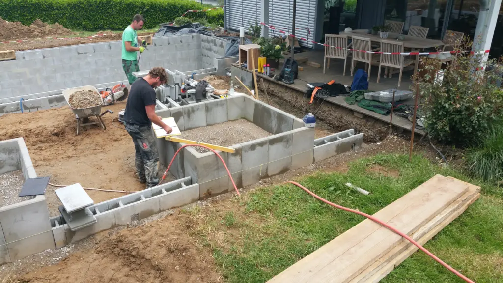 Hybridpool mit Natursteinelementen und Holzterrasse