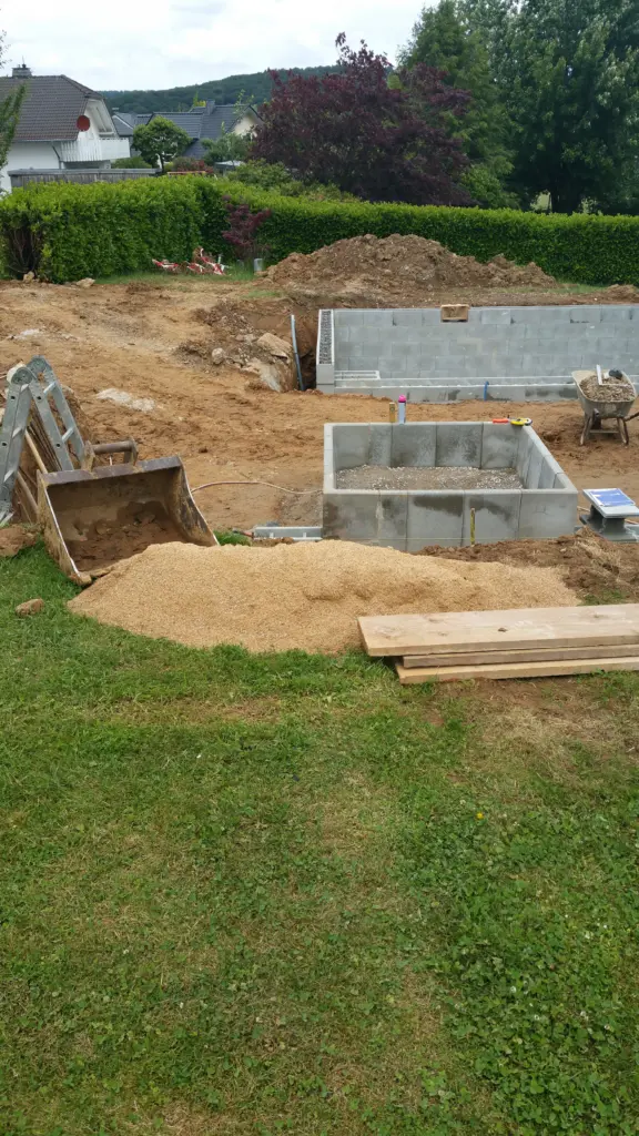 Hybridpool mit Natursteinelementen und Holzterrasse