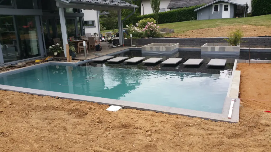 Hybridpool mit Natursteinelementen und Holzterrasse