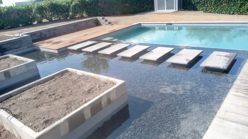 Hybridpool mit Natursteinelementen und Holzterrasse
