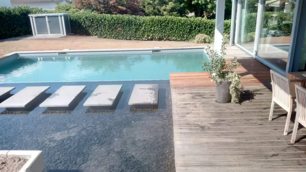 Hybridpool mit Natursteinelementen und Holzterrasse