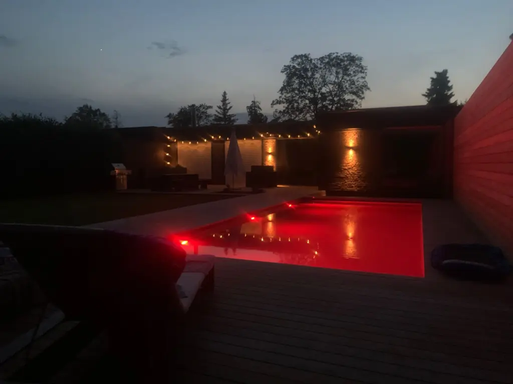Moderner Pool mit Holzterrasse und Loungebereich