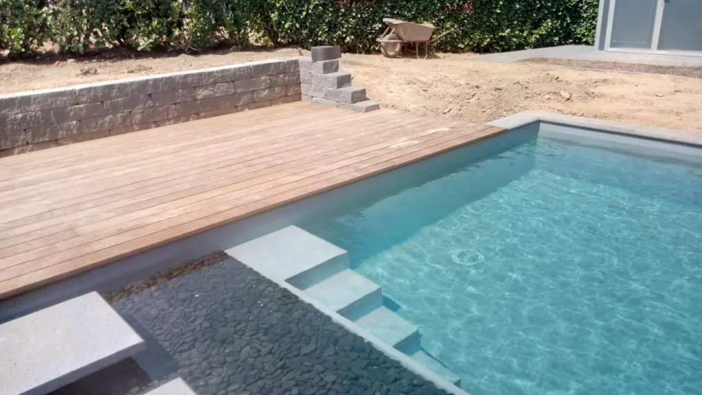 Hybridpool mit Natursteinelementen und Holzterrasse
