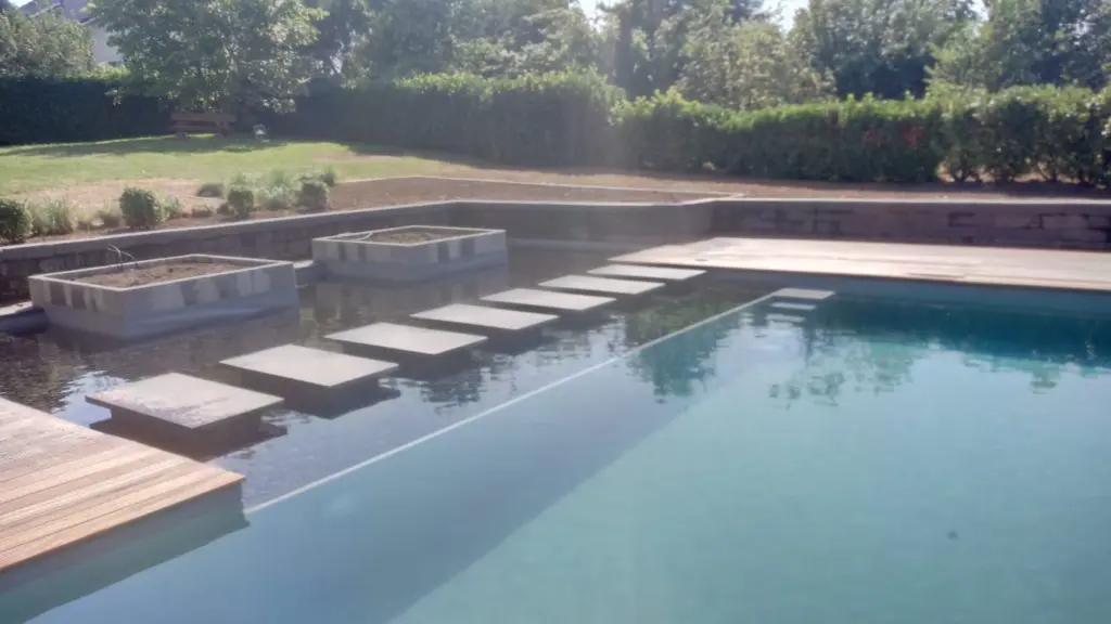 Hybridpool mit Natursteinelementen und Holzterrasse