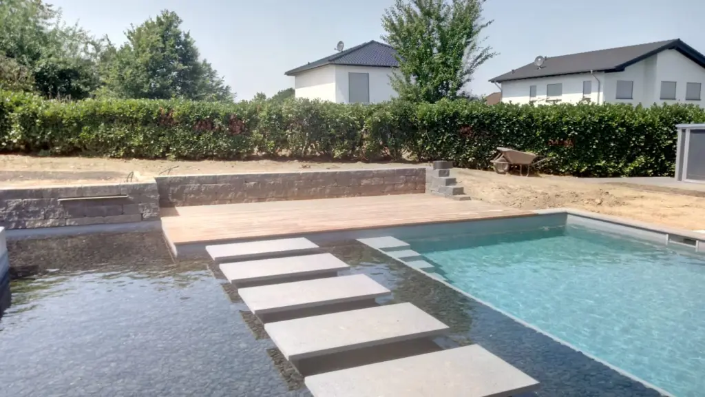Hybridpool mit Natursteinelementen und Holzterrasse