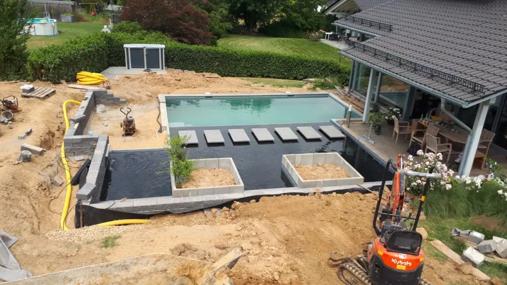 Hybridpool mit Natursteinelementen und Holzterrasse