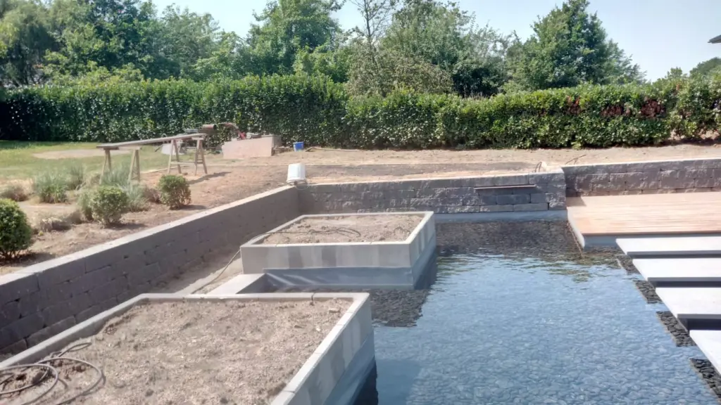Hybridpool mit Natursteinelementen und Holzterrasse