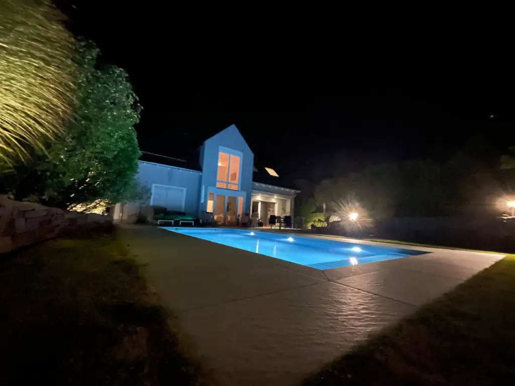 Salzwasserpool mit Abendbeleuchtung im terrassierten Garten
