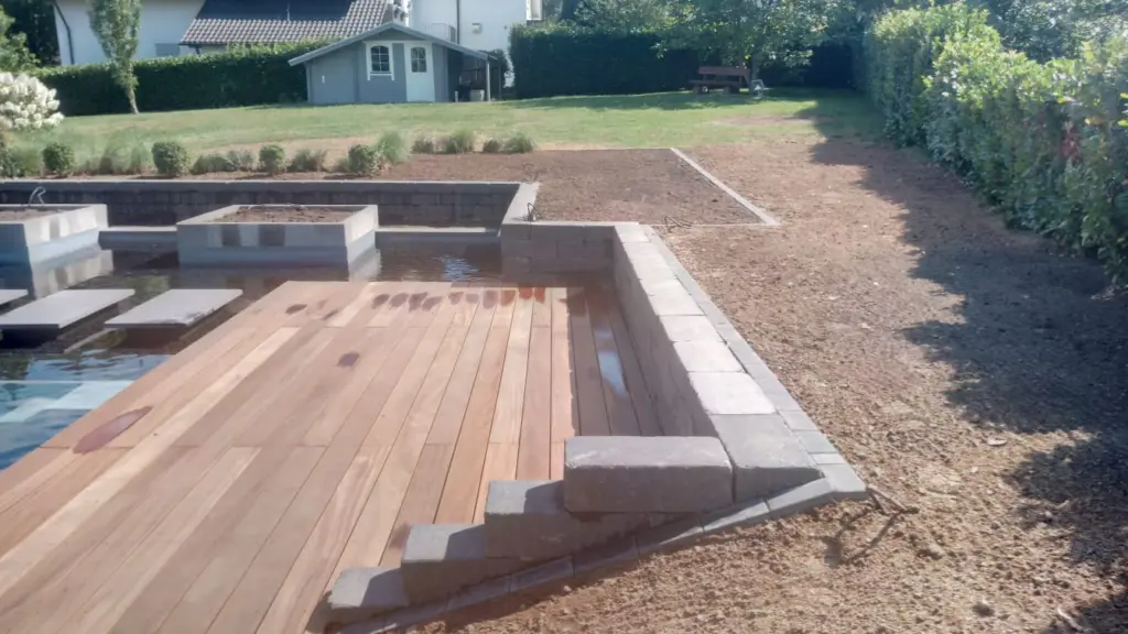 Hybridpool mit Natursteinelementen und Holzterrasse