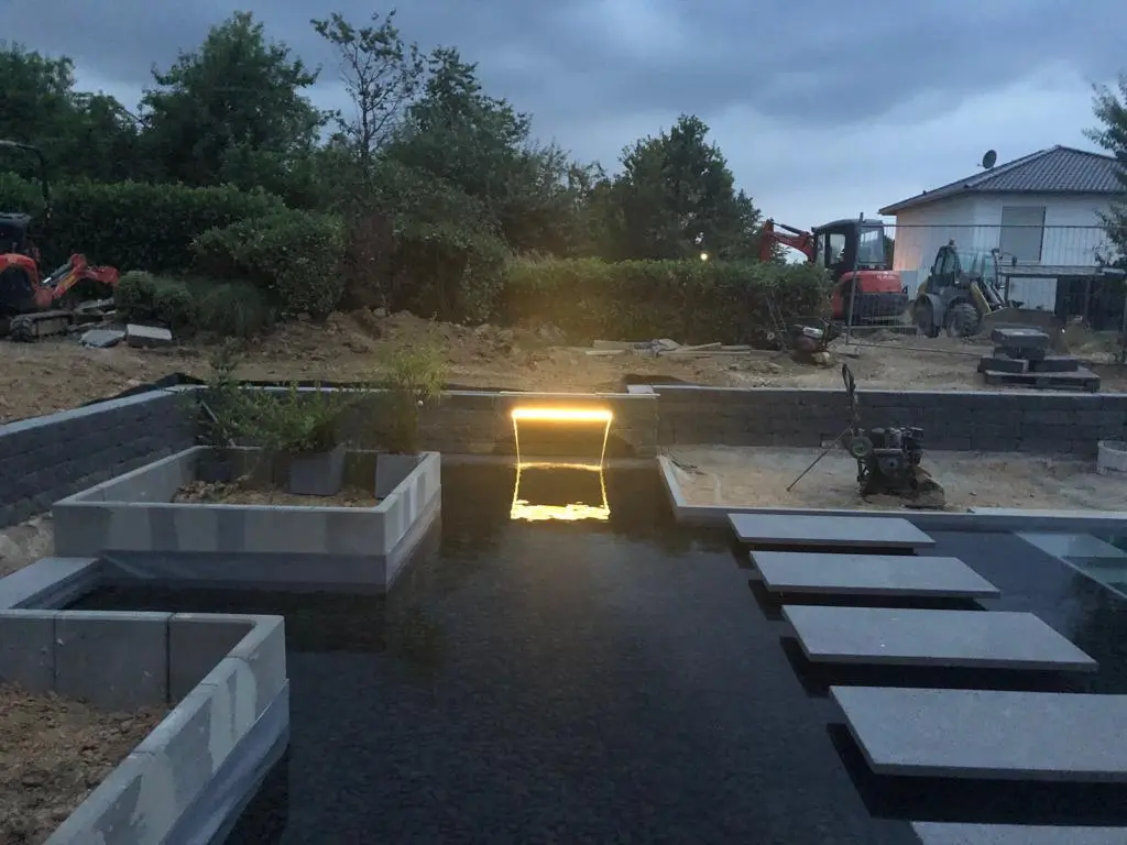Hybridpool mit Natursteinelementen und Holzterrasse