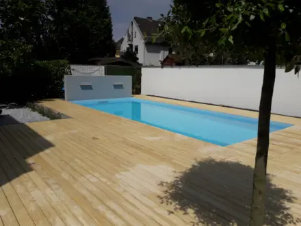 Salzwasserpool mit Holzdeck und Wasserspielwand