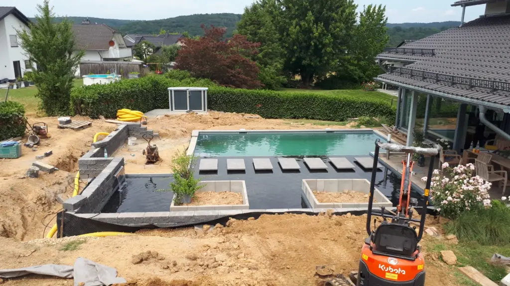 Hybridpool mit Natursteinelementen und Holzterrasse