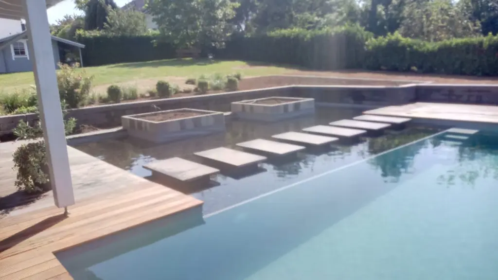 Hybridpool mit Natursteinelementen und Holzterrasse