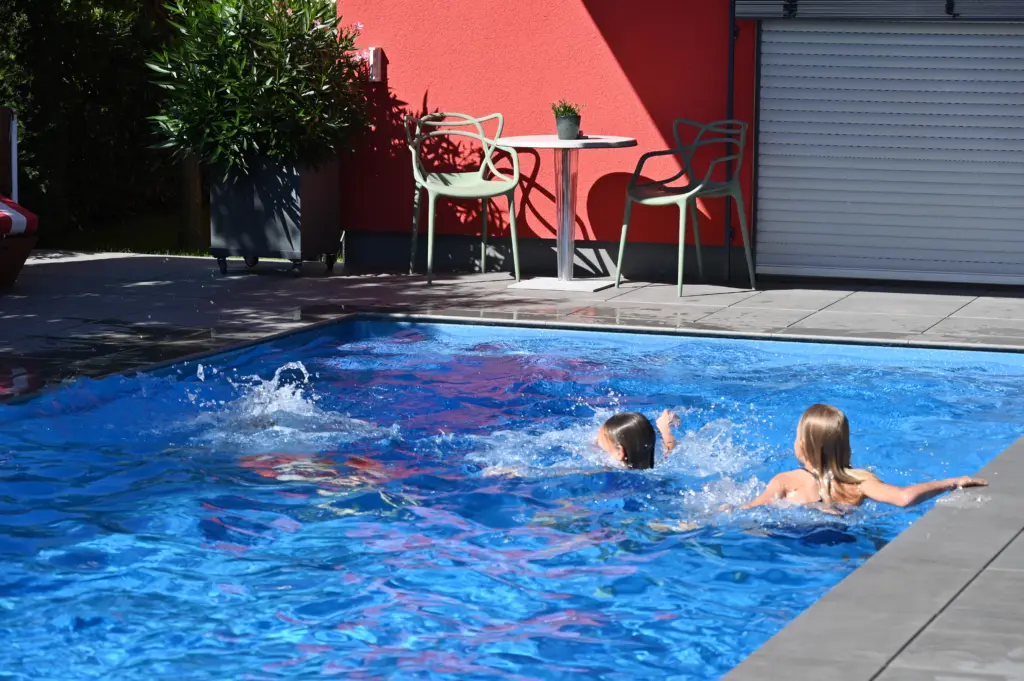 Swimmingpool mit Sitzbänken und Sichtschutz