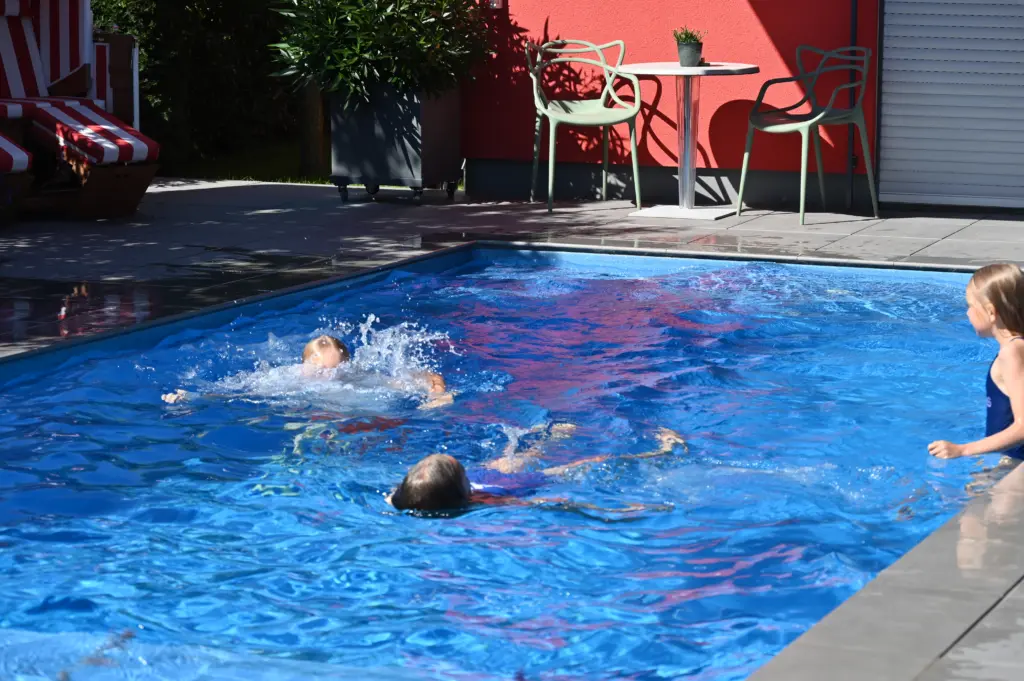 Swimmingpool mit Sitzbänken und Sichtschutz