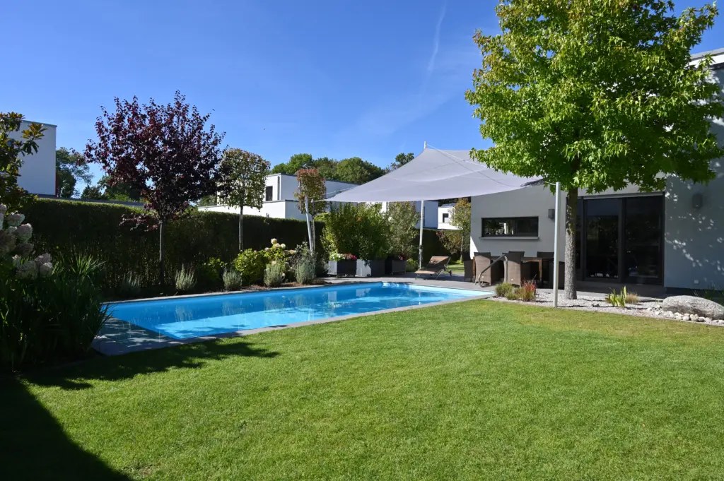 Poolanlage mit Blütengarten und Terrassenfläche