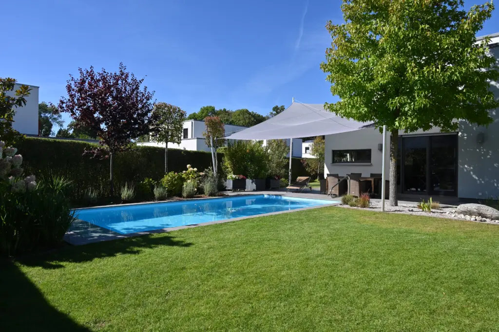 Poolanlage mit Blütengarten und Terrassenfläche