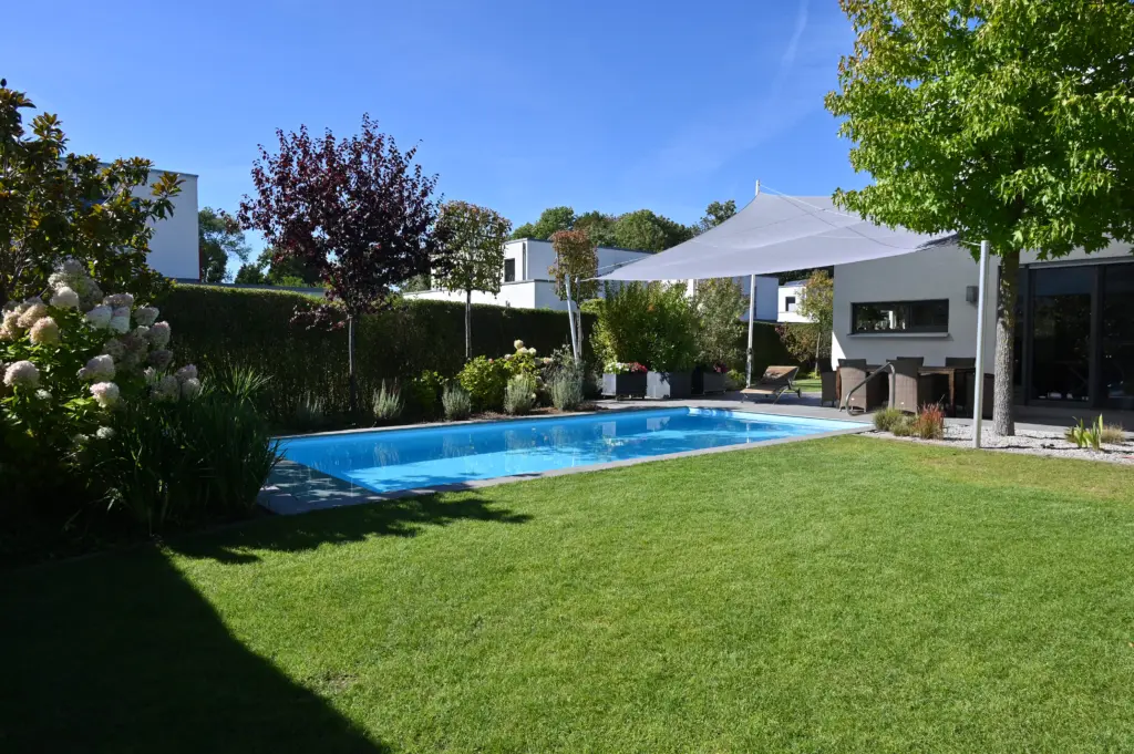 Poolanlage mit Blütengarten und Terrassenfläche