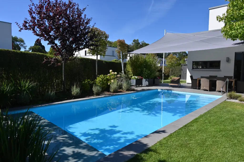 Poolanlage mit Blütengarten und Terrassenfläche