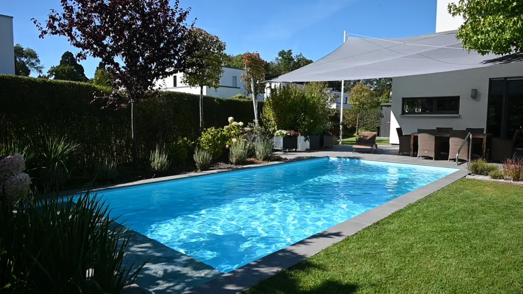 Poolanlage mit Blütengarten und Terrassenfläche