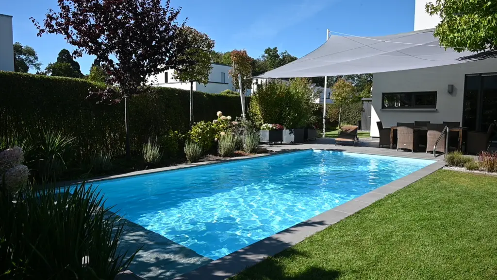 Poolanlage mit Blütengarten und Terrassenfläche