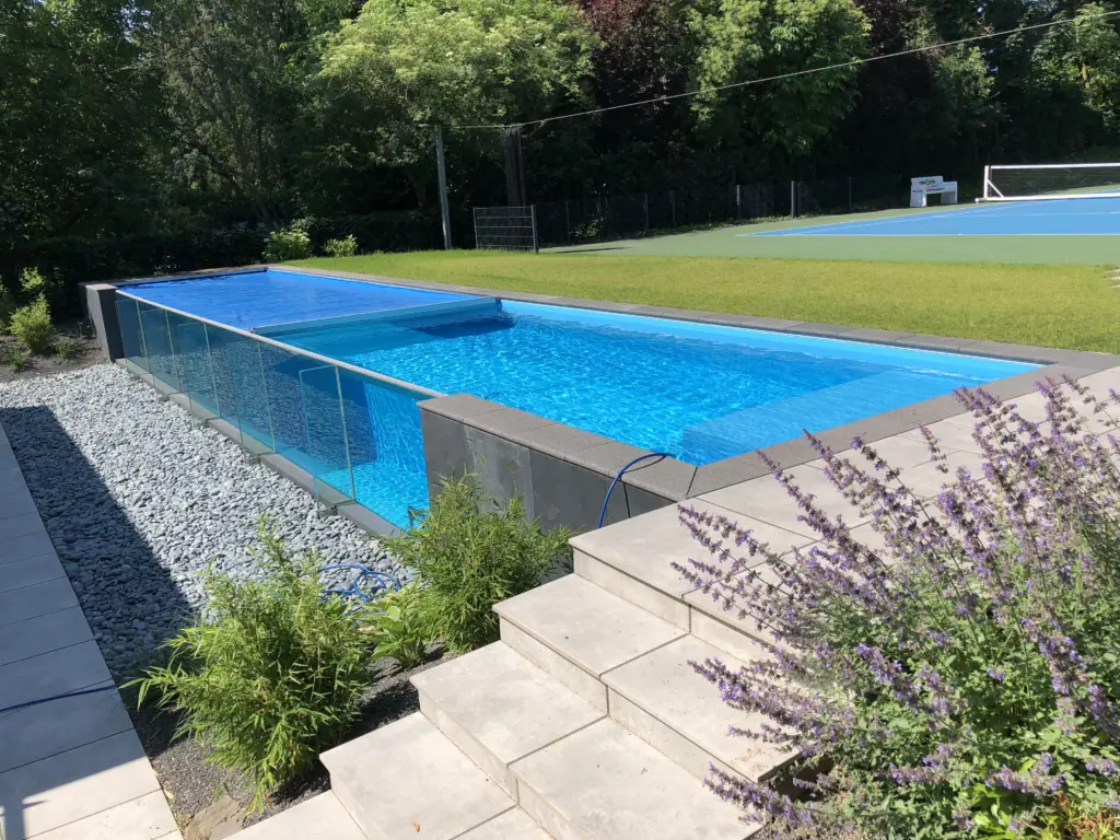 Glaswandpool mit geschlossener blauer Poolabdeckung