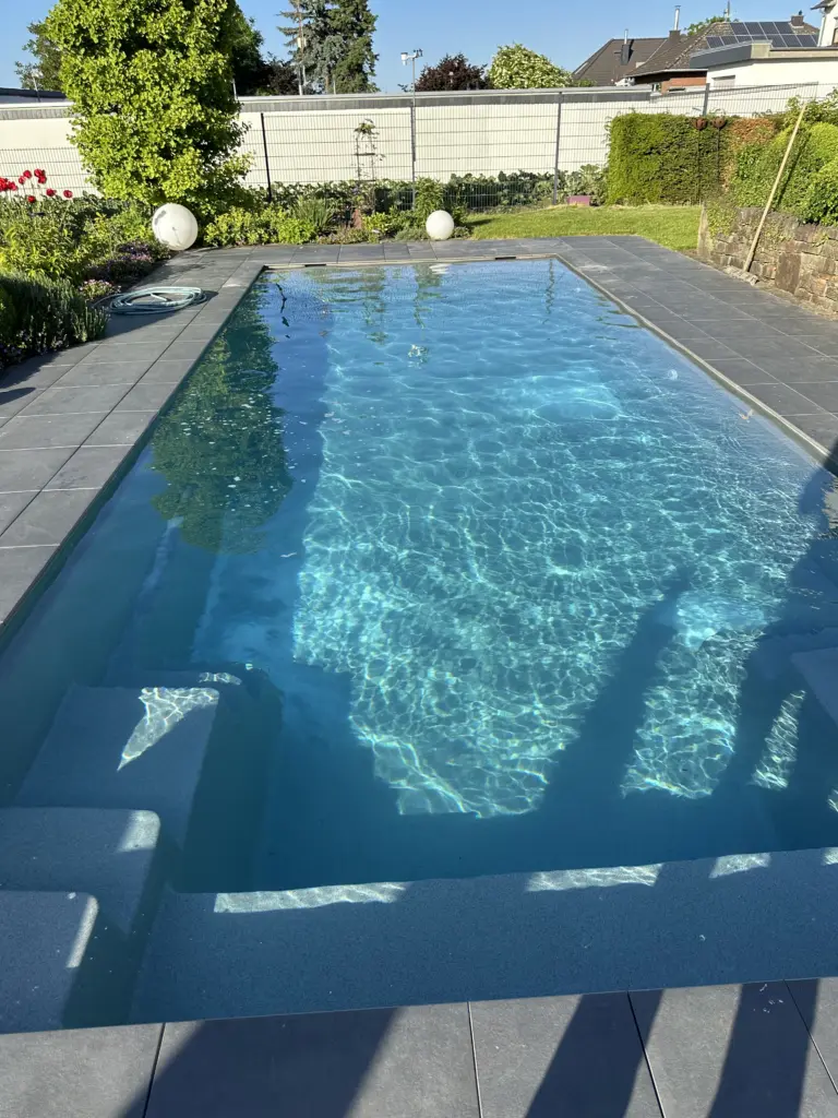 Geradliniger Pool mit bepflanztem Gartenumfeld