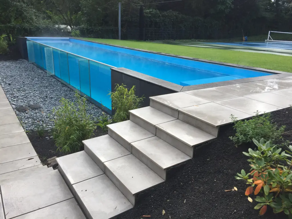 Offener Glaswandpool mit heller Treppenanlage