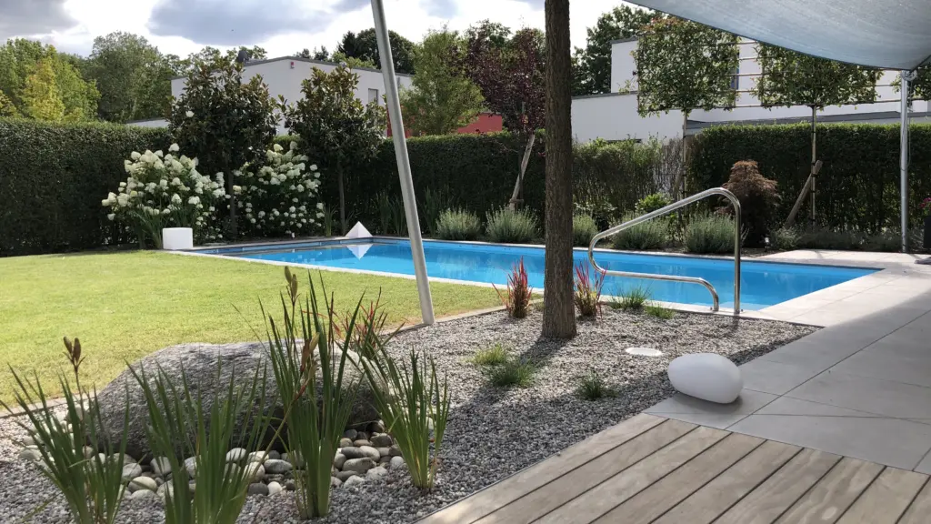 Poolanlage mit Blütengarten und Terrassenfläche