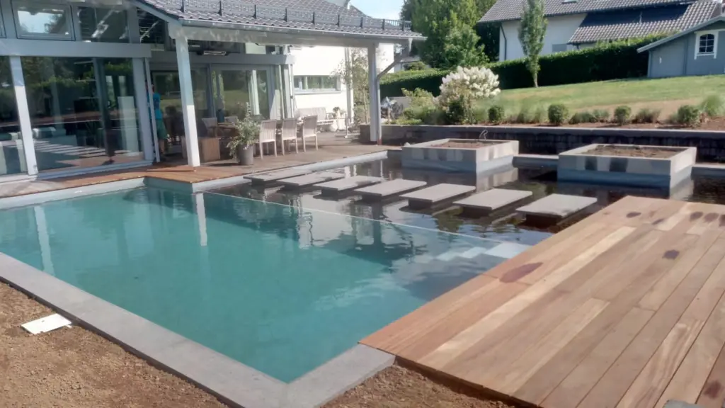 Hybridpool mit Natursteinelementen und Holzterrasse