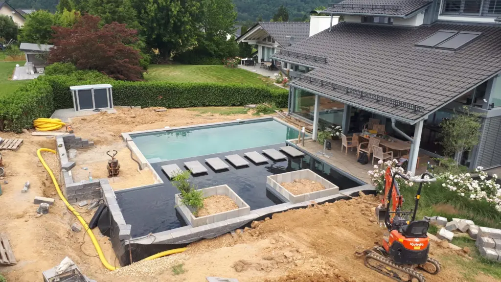 Hybridpool mit Natursteinelementen und Holzterrasse