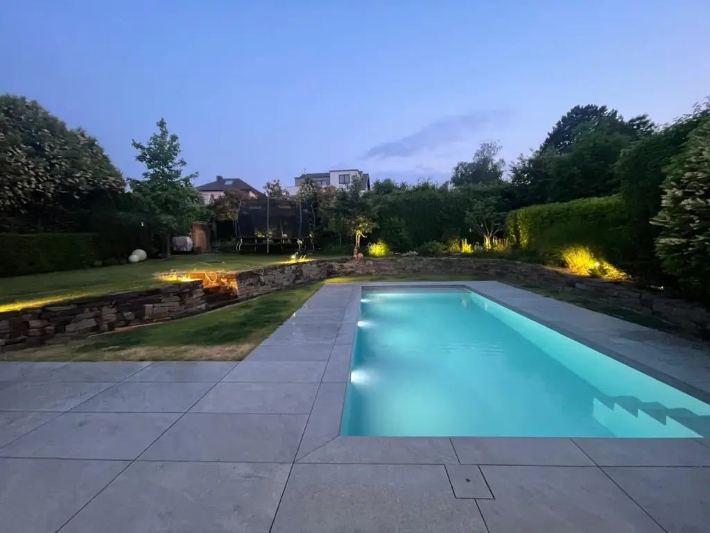 Salzwasserpool mit Abendbeleuchtung im terrassierten Garten