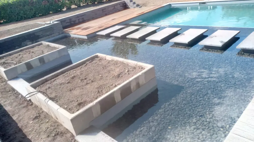 Hybridpool mit Natursteinelementen und Holzterrasse