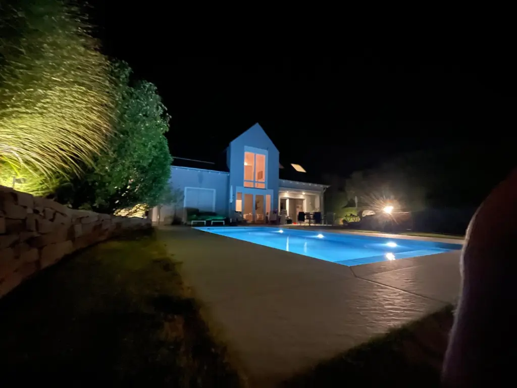 Salzwasserpool mit Abendbeleuchtung im terrassierten Garten