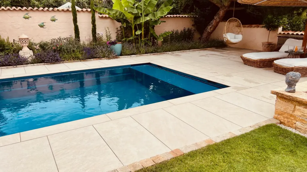 Moderner Pool mit heller Terrassenfläche und Poolhaus